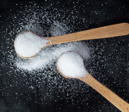 Two wooden spoons full of salt
