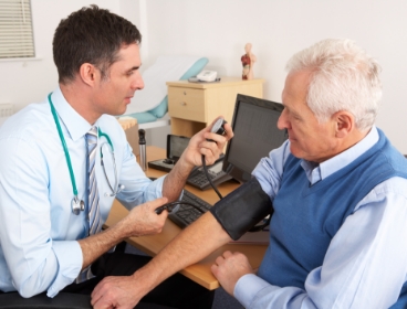 GP checking patient's blood pressure